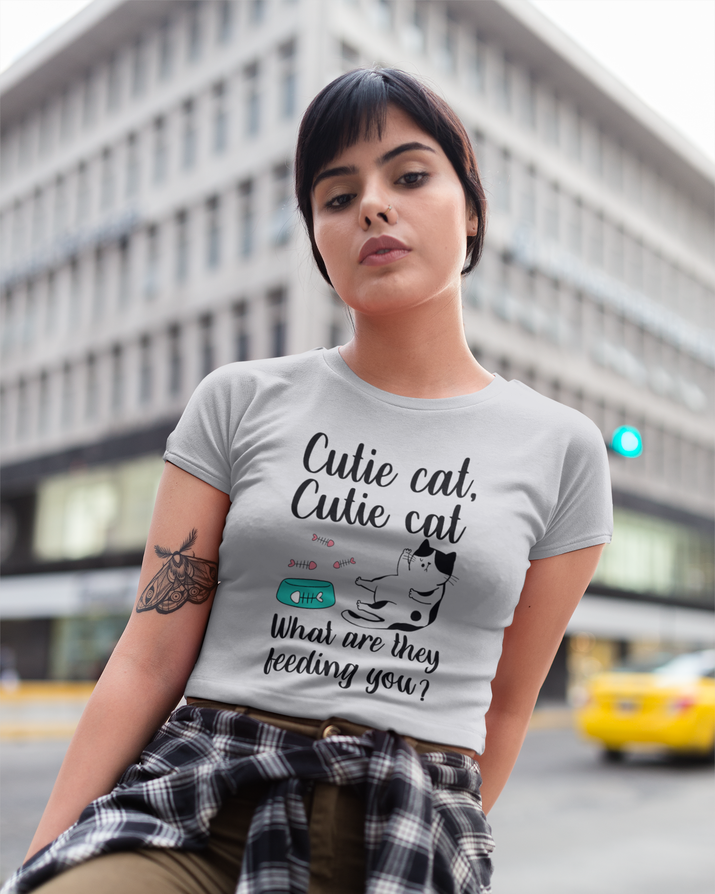Woman wearing a t-shirt with a cat-themed design in an urban setting