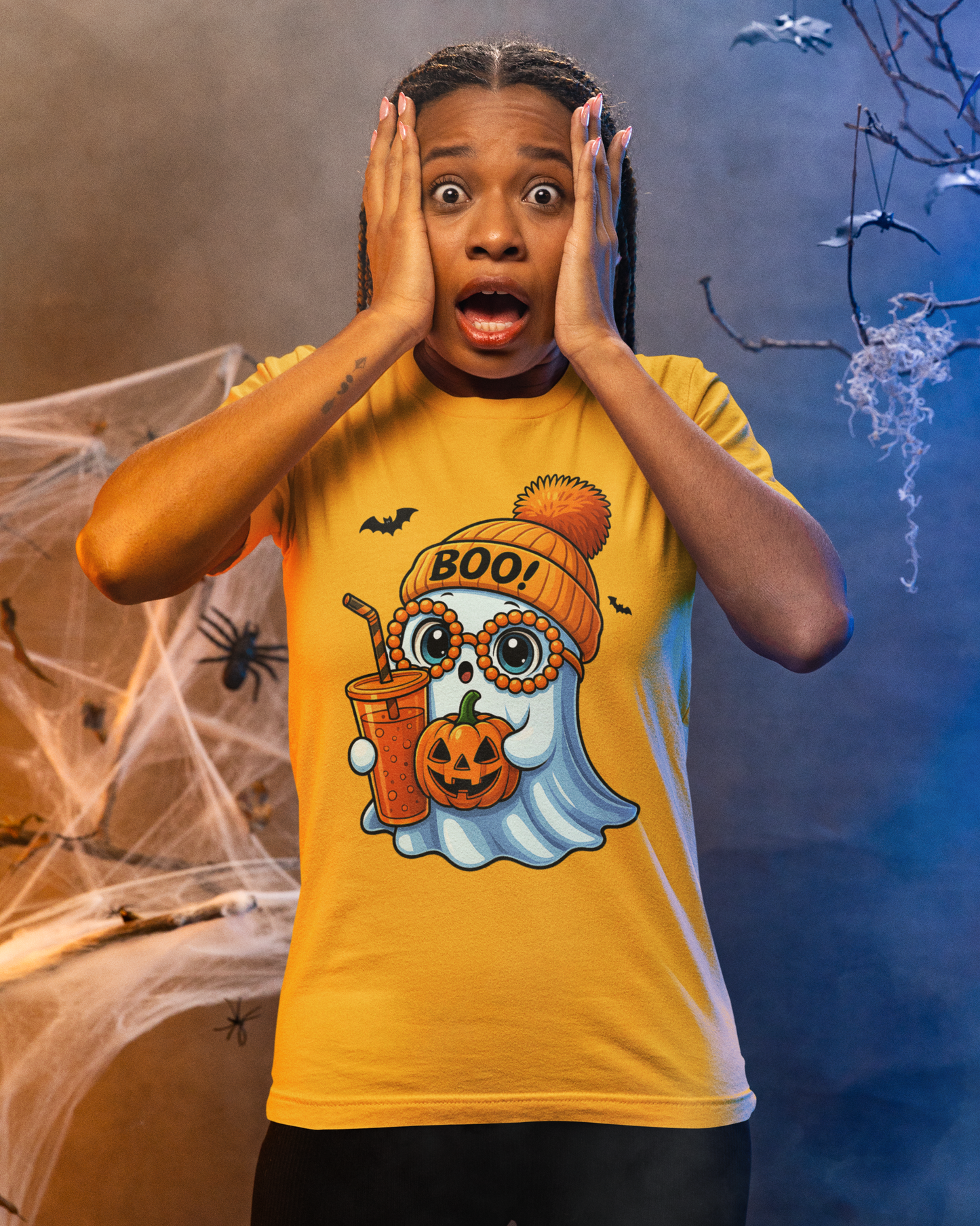 Child wearing a Halloween-themed t-shirt with ghost and pumpkin design, surrounded by spider webs and bats.