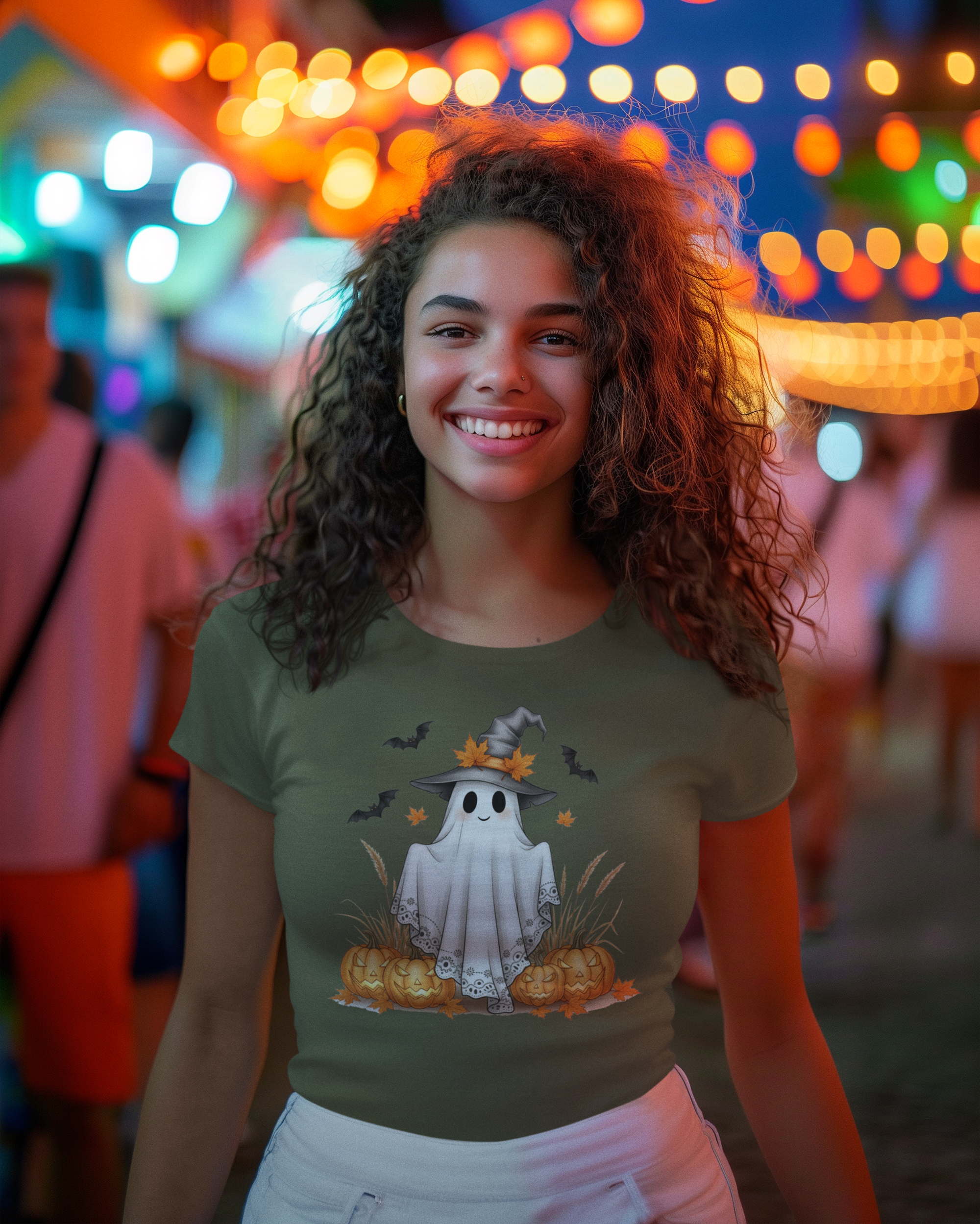 Woman wearing a Halloween-themed t-shirt with ghost and pumpkin design in a festive outdoor setting.