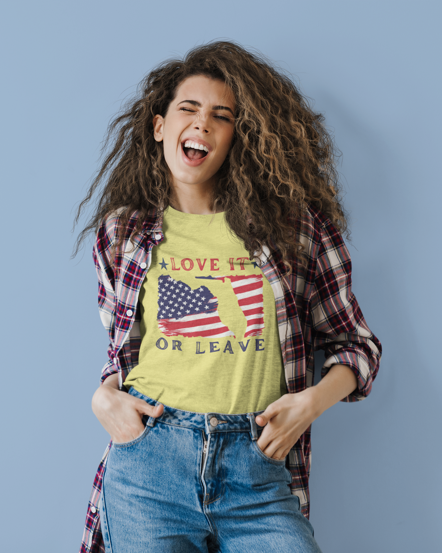 Woman wearing a yellow graphic t-shirt with an American flag design on a blue background