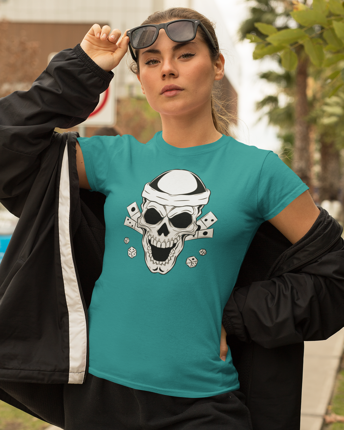 Person wearing a teal t-shirt with a skull design outdoors