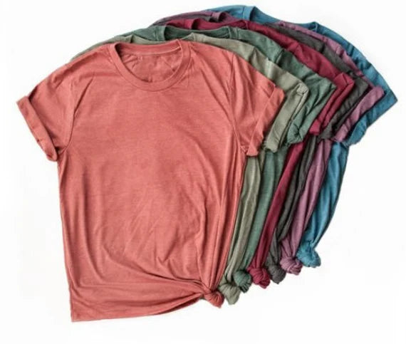 Stack of plain t-shirts in various colors on a white background