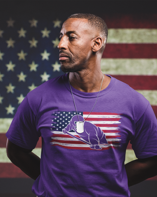 Man wearing a purple t-shirt with an American flag design in front of an American flag background