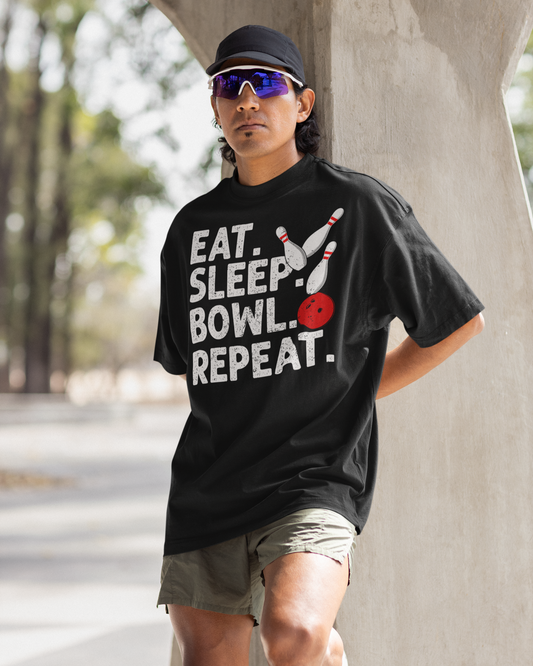 Person wearing a black t-shirt with 'Eat. Sleep. Bowl. Repeat.' text, standing outdoors.