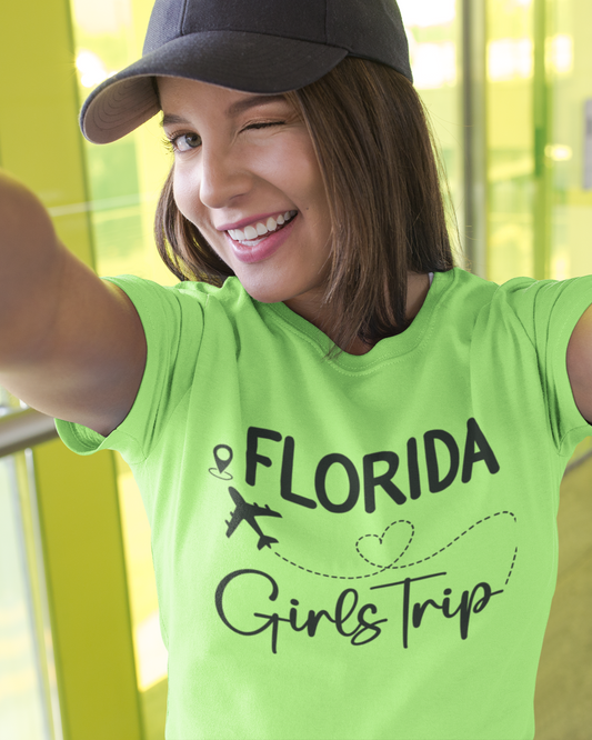 Woman wearing a green 'Florida Girls Trip' t-shirt with arms outstretched.
