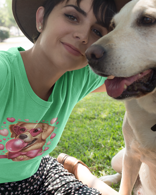 Woman wearing a green t-shirt with a dog graphic, sitting next to a white dog outdoors.