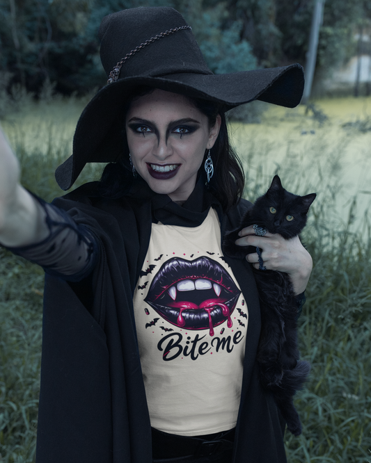 Woman in a witch costume holding a black cat with a 'Bite me' shirt in a outdoor setting