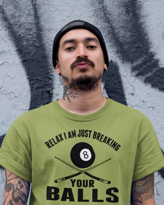 Person wearing a green t-shirt with a graphic and text in front of a graffiti-covered wall.